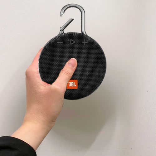 Käsi pitää langatonta kaiutinta